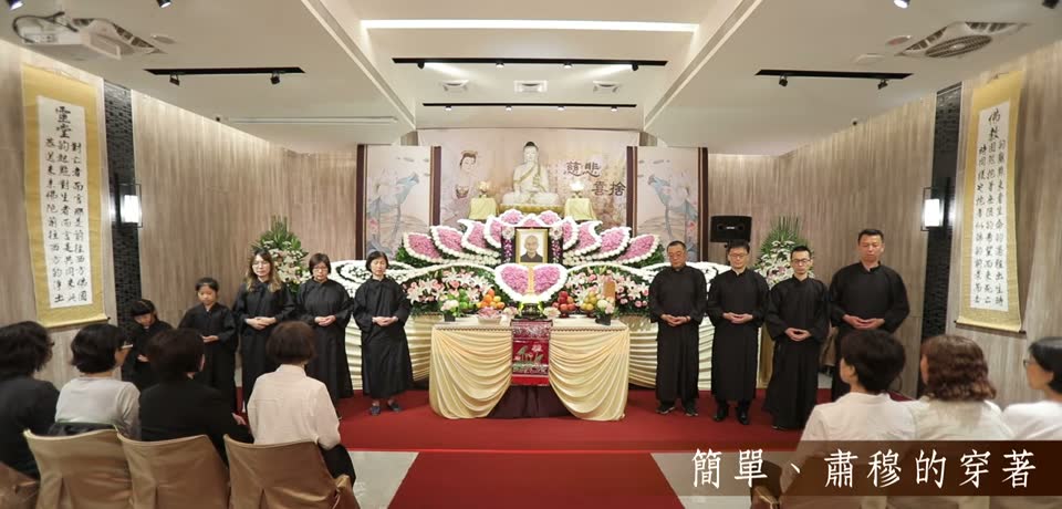 家屬穿黑色衣鞋與黑袍站在佛壇前